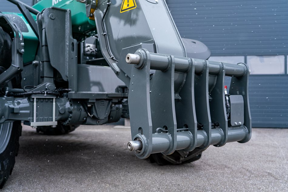 Masivní rameno výložníku je vybaveno hydraulicky ovládaným jištěním s čepy o průměru 50 mm, které zajišťuje vysokou pevnost, dlouhou životnost a maximální bezpečnost i při práci s těžkým nářadím.